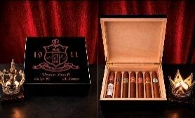 Black 1911-engraved humidor open to show cedar interior filled with cigars, against a red backdrop
