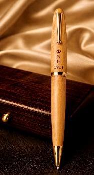 Wide maple ballpoint pen with chrome trim engraved NUPE 1911, on a dark wood surface