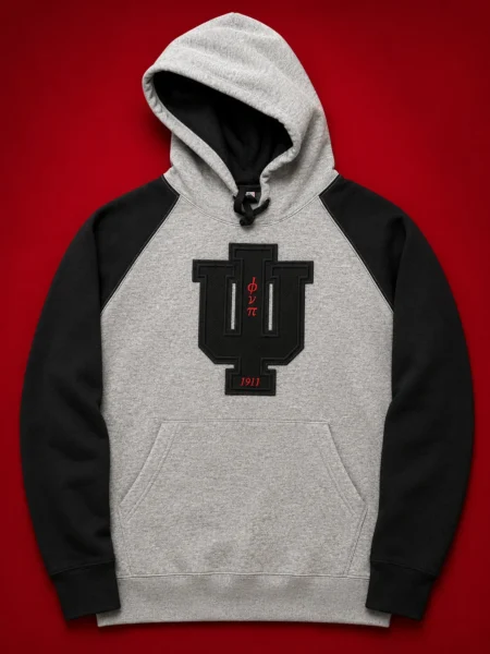 Custom grey and black raglan two-tone pullover hoodie with black PVC patch insignia and crimson Greek letter abbreviations and founding year on front chest.
