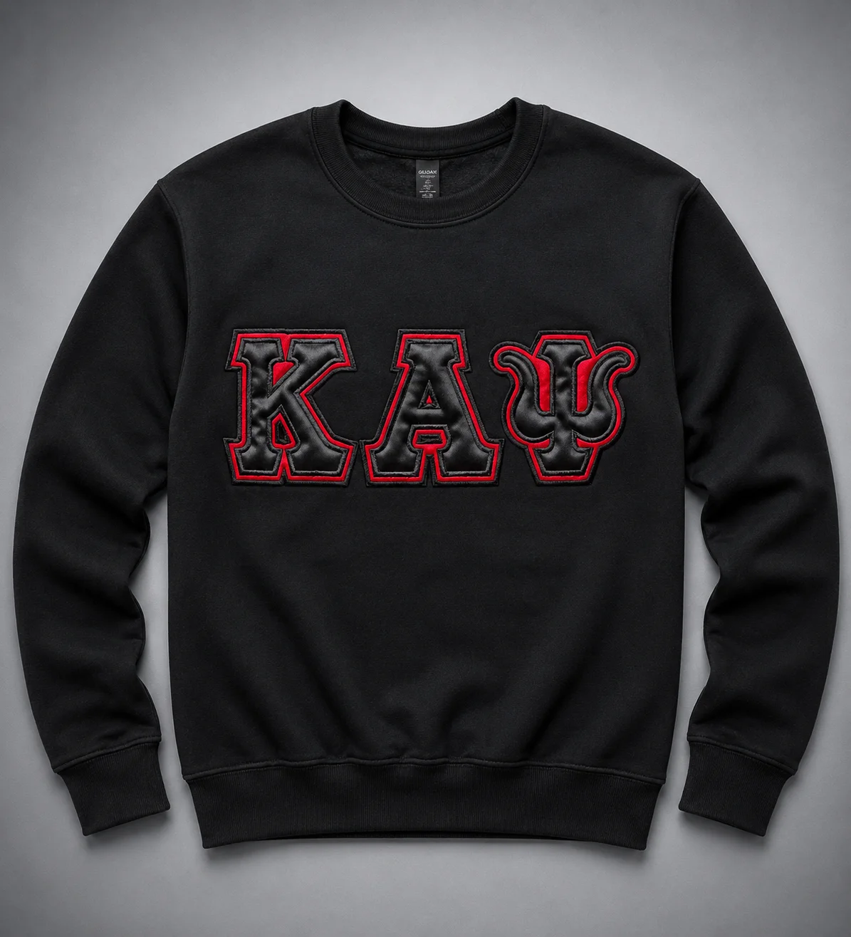Custom black heavyweight crewneck sweatshirt with oversized tonal satin Greek letter appliqué, black inner outline, and crimson embroidered border on chest.